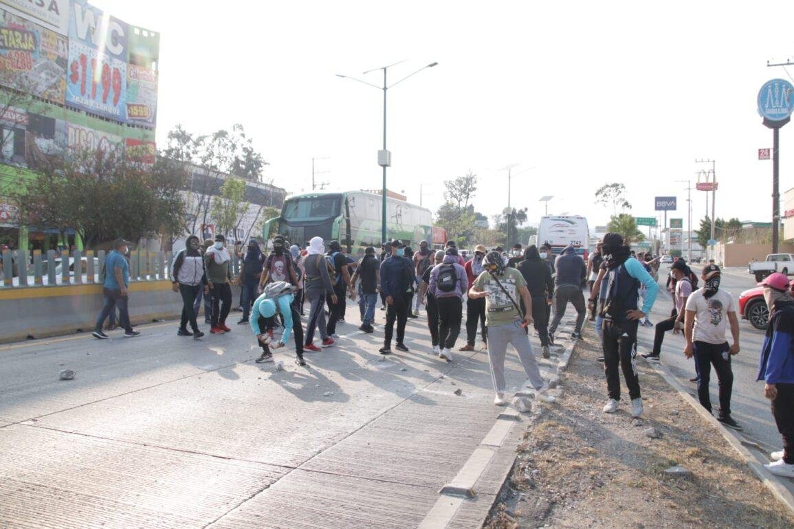 Chocan normalistas de Ayotzinapa con policías antimotines en Autopista del Sol