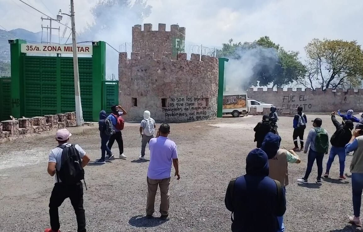Normalistas de Ayotzinapa lanzan petardos en zona militar y soldados responden con gases lacrimógenos